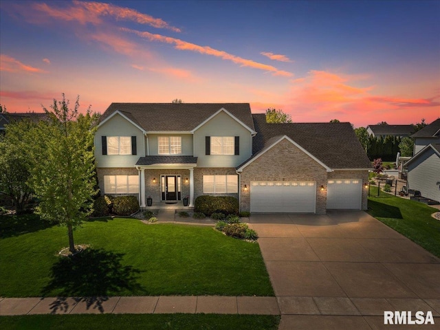 traditional home featuring a garage, concrete driveway, a yard, and brick siding