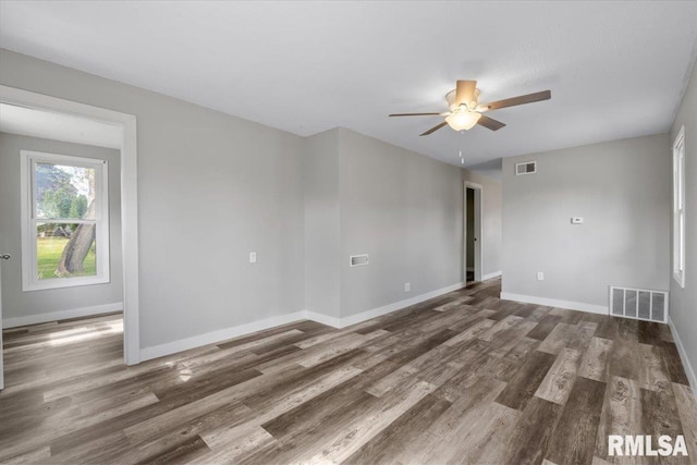 empty room featuring a ceiling fan, wood finished floors, and baseboards