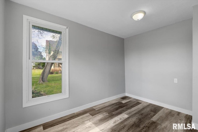 unfurnished room with wood finished floors and baseboards