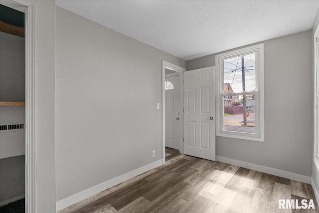 unfurnished bedroom with wood finished floors and baseboards