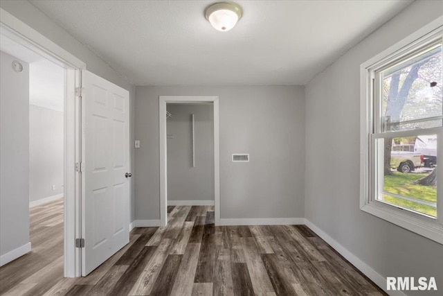 unfurnished bedroom with wood finished floors and baseboards