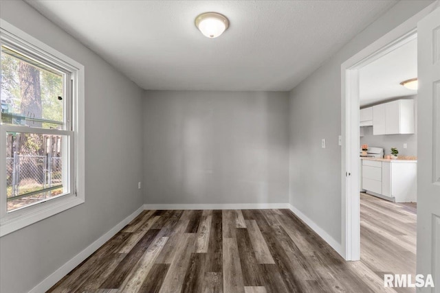 spare room with wood finished floors and baseboards