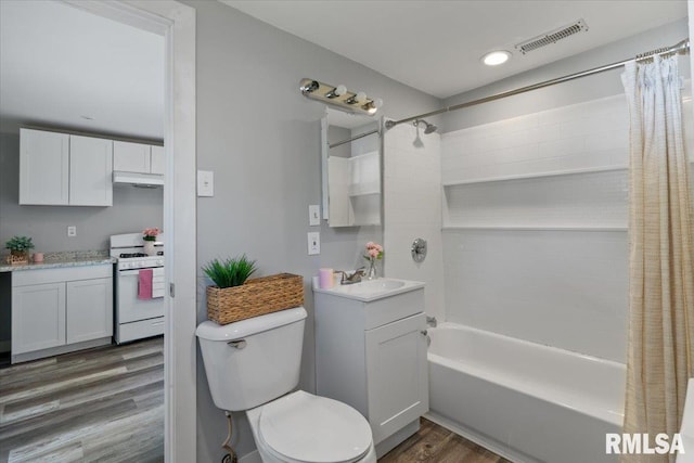 bathroom featuring wood finished floors, shower / bathtub combination with curtain, toilet, and vanity