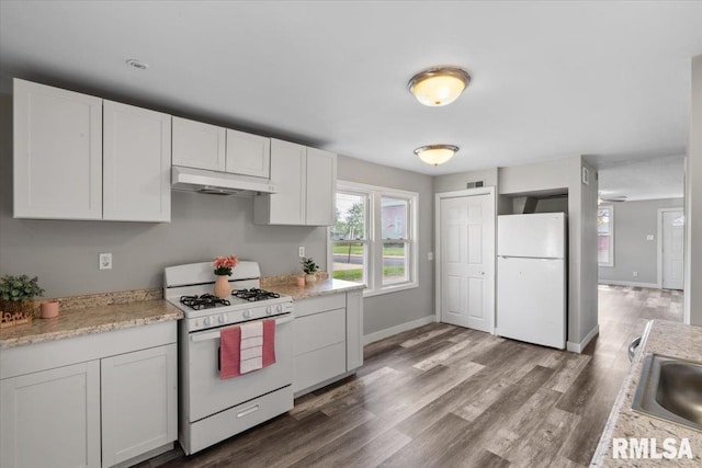 kitchen featuring white appliances, under cabinet range hood, wood finished floors, white cabinetry, and baseboards