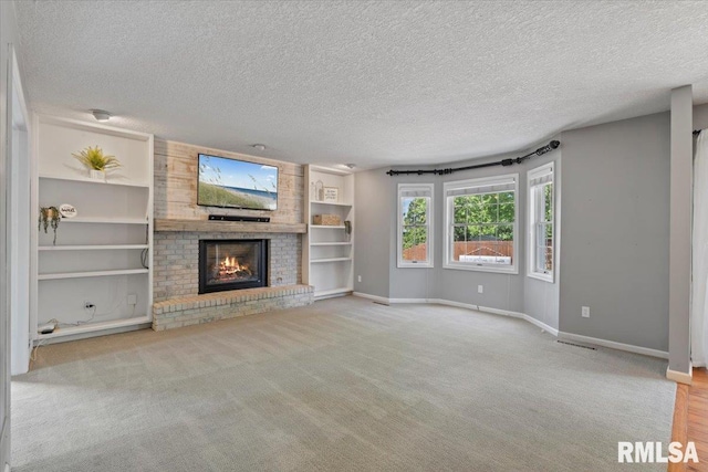 4690 Lindbergh Dr, Bettendorf, IA 52722 - unfurnished living room featuring a textured ceiling, baseboards, a brick fireplace, carpet flooring, and built in shelves
