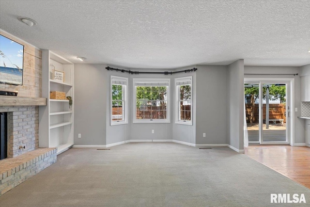 4690 Lindbergh Dr, Bettendorf, IA 52722 - unfurnished living room featuring a brick fireplace, carpet, plenty of natural light, a textured ceiling, and baseboards