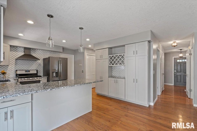 4690 Lindbergh Dr, Bettendorf, IA 52722 - kitchen with appliances with stainless steel finishes, wall chimney range hood, decorative backsplash, light wood-type flooring, and light stone countertops