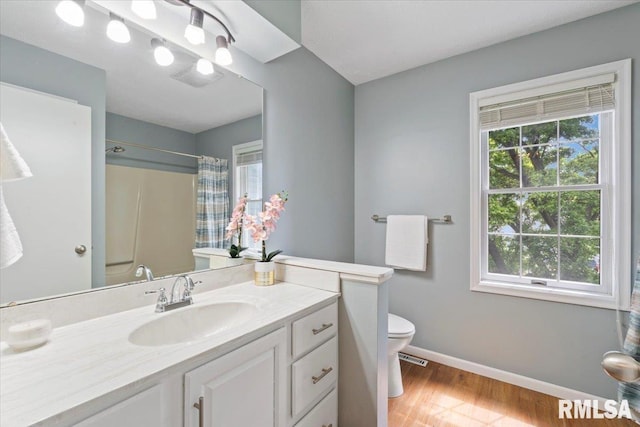 4690 Lindbergh Dr, Bettendorf, IA 52722 - full bathroom with toilet, wood finished floors, baseboards, a shower with shower curtain, and vanity