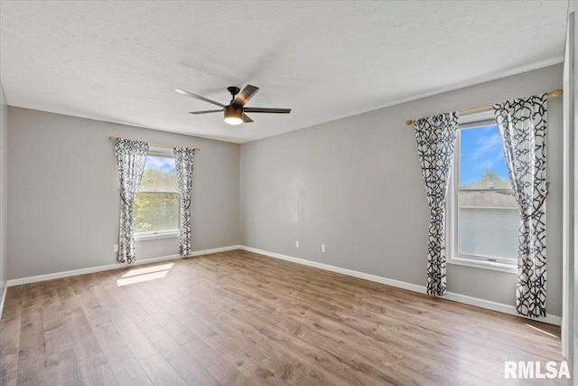 4690 Lindbergh Dr, Bettendorf, IA 52722 - unfurnished room with wood finished floors, a ceiling fan, baseboards, and a textured ceiling
