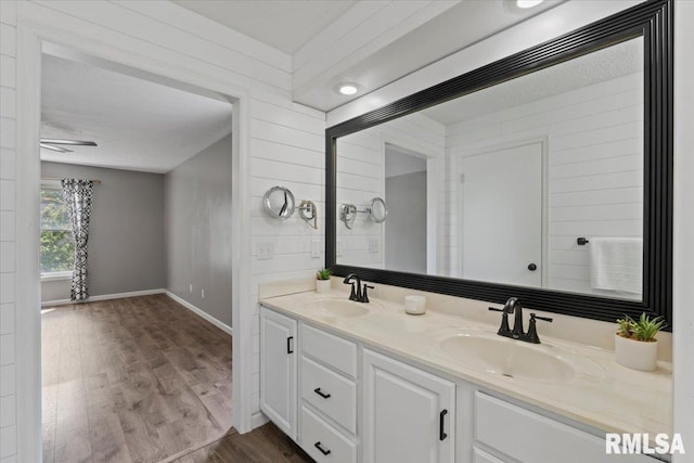 4690 Lindbergh Dr, Bettendorf, IA 52722 - full bathroom featuring wood finished floors, double vanity, and baseboards