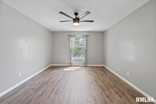 4690 Lindbergh Dr, Bettendorf, IA 52722 - unfurnished room with a ceiling fan, wood finished floors, baseboards, and a textured ceiling