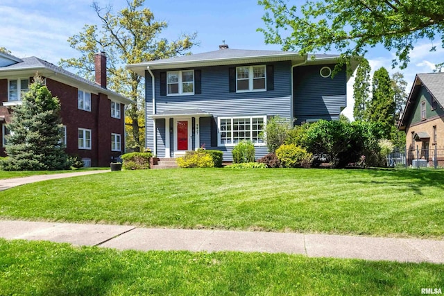 view of front of house featuring a front lawn and a chimney