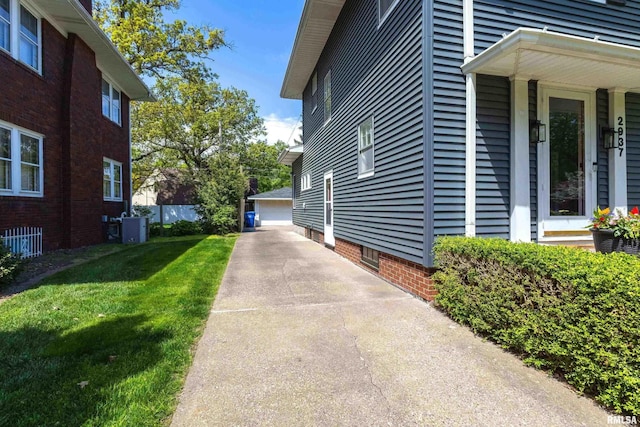 view of property exterior with a lawn and a detached garage