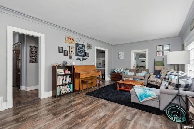 living room with wood finished floors, ornamental molding, and baseboards