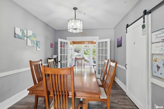 dining area featuring a barn door, a chandelier, dark wood finished floors, baseboards, and french doors