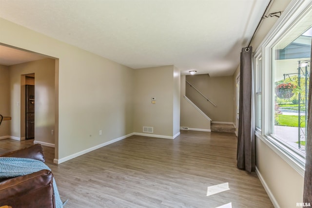 1960 Tam-O-Shanter Dr, Bettendorf, IA 52722 - unfurnished room with light wood-style flooring, baseboards, and stairway