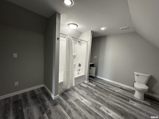 bathroom with vaulted ceiling, wood finished floors, shower / tub combo with curtain, toilet, and baseboards