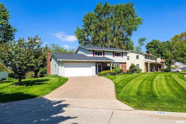traditional-style home featuring a garage, a front lawn, driveway, and a chimney