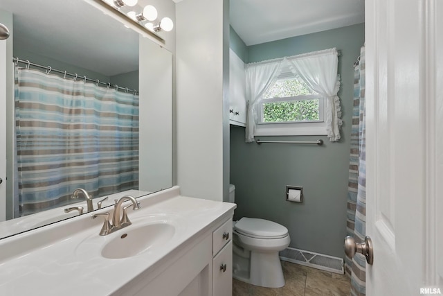 full bathroom with toilet, vanity, tile patterned floors, and baseboards