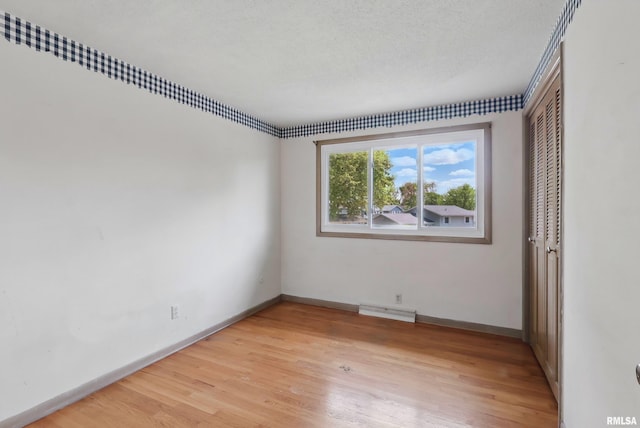 unfurnished room with light wood finished floors and baseboards