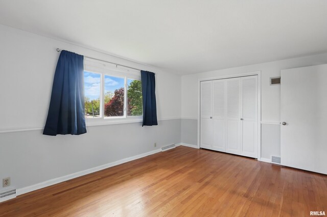 unfurnished bedroom with light wood finished floors, a closet, and baseboards