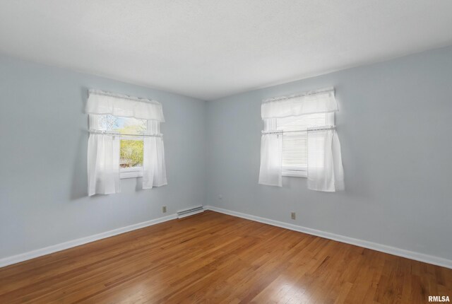 unfurnished room featuring wood finished floors and baseboards