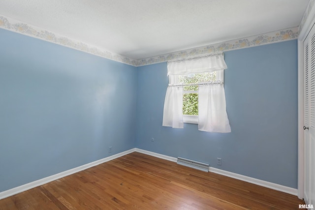 unfurnished room featuring baseboards and wood finished floors