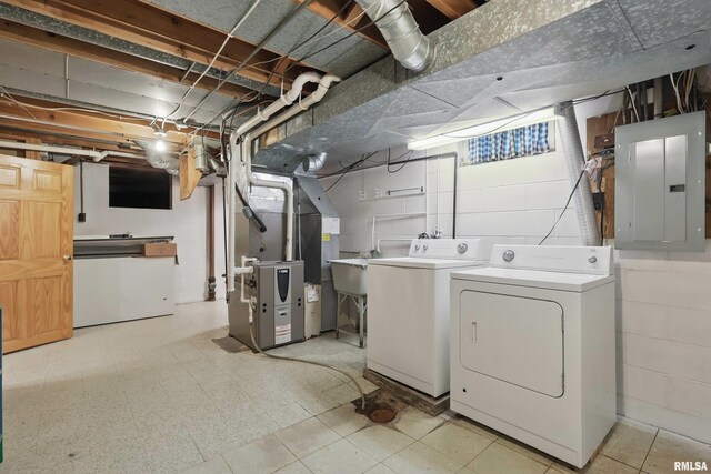 laundry area featuring electric panel, independent washer and dryer, heating unit, and light floors