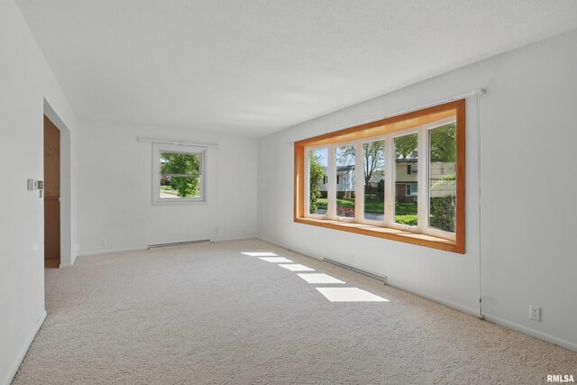 unfurnished room featuring baseboard heating, carpet flooring, a baseboard radiator, and baseboards