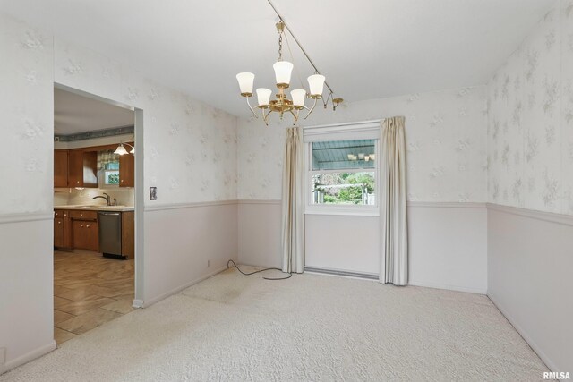 unfurnished dining area with a chandelier, a sink, wallpapered walls, and light colored carpet