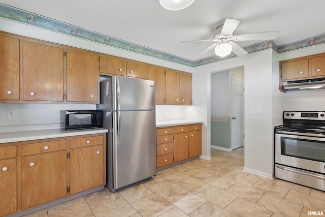 kitchen with appliances with stainless steel finishes, under cabinet range hood, light countertops, and ceiling fan