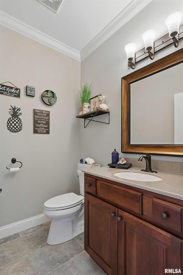 bathroom with crown molding, toilet, baseboards, vanity, and stone finish floors