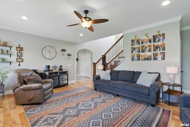 living room featuring arched walkways, stairway, a ceiling fan, crown molding, and recessed lighting