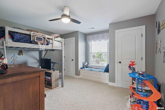 carpeted bedroom with a ceiling fan, a desk, and baseboards