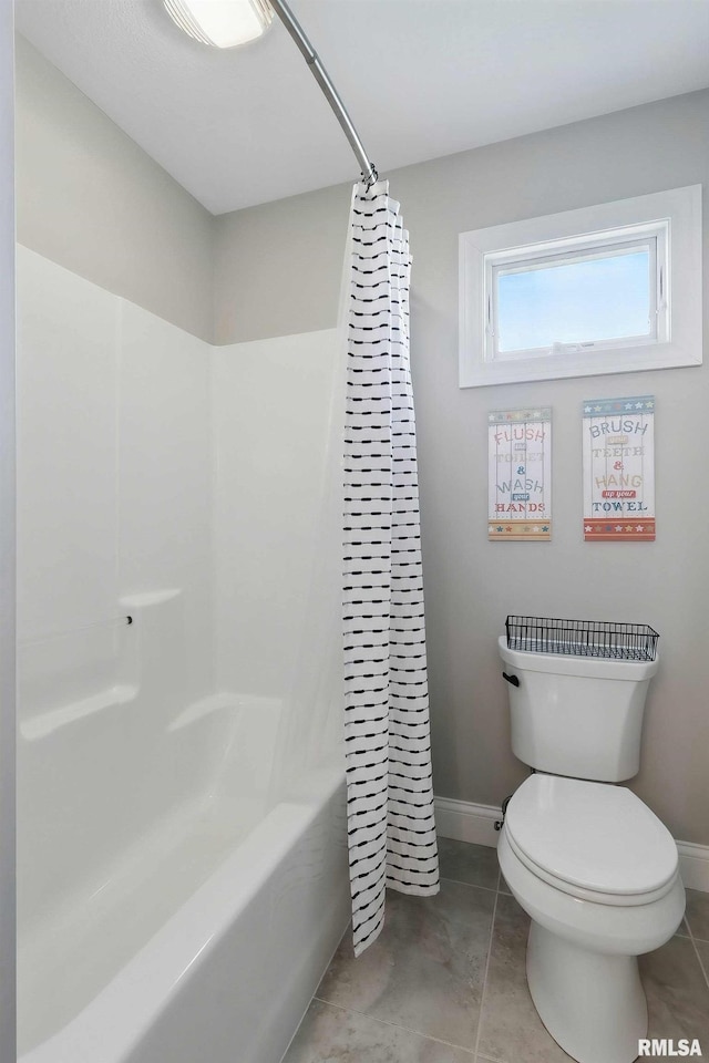 bathroom featuring toilet, baseboards, and tile patterned flooring
