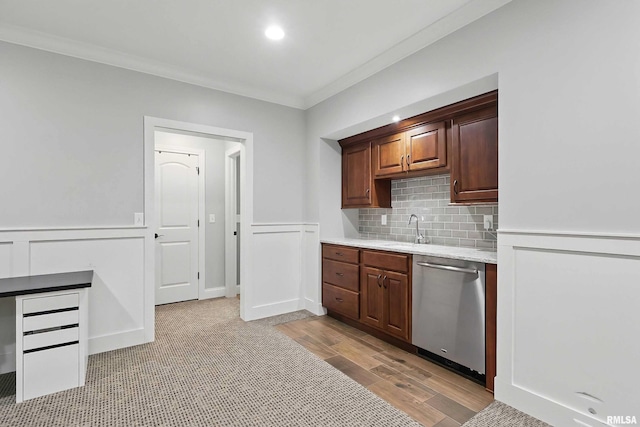 kitchen featuring stainless steel dishwasher, ornamental molding, light wood-style floors, decorative backsplash, and wainscoting