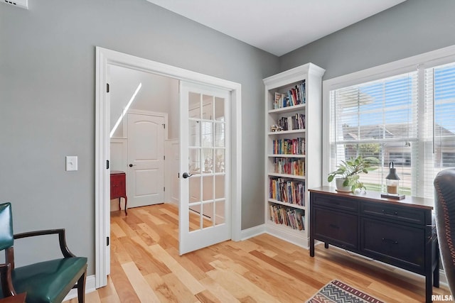 sitting room featuring light wood-style flooring, baseboards, and french doors