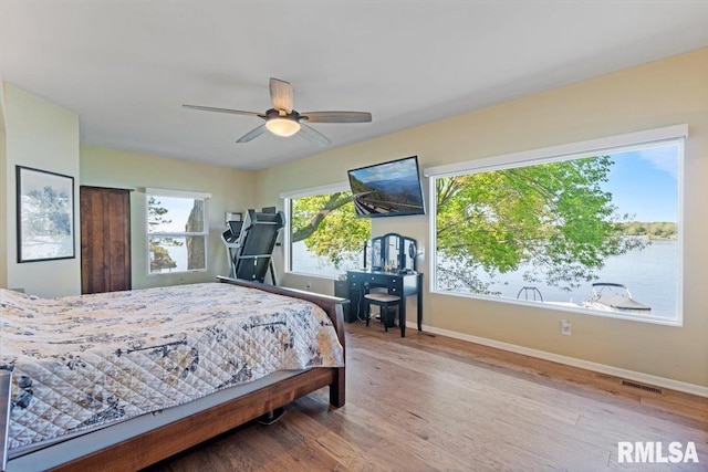 bedroom with baseboards, wood finished floors, and a ceiling fan