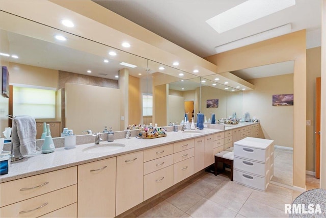 bathroom featuring recessed lighting, tile patterned floors, double vanity, and a skylight