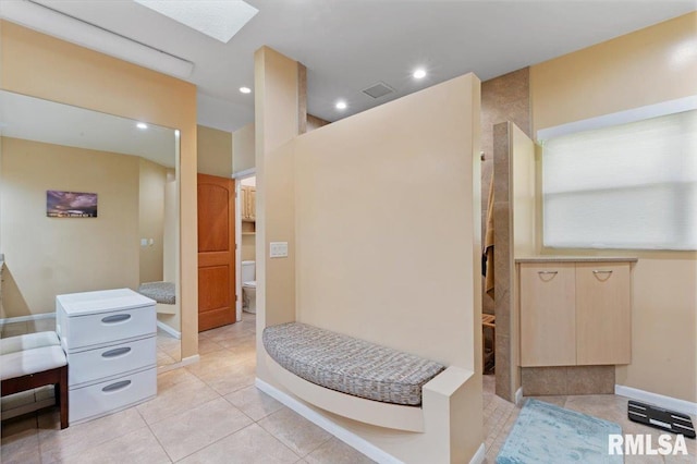 bathroom with walk in shower, toilet, tile patterned floors, recessed lighting, and a skylight