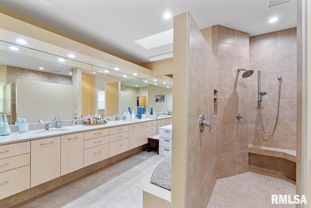 bathroom featuring walk in shower, double vanity, a skylight, tile patterned floors, and recessed lighting