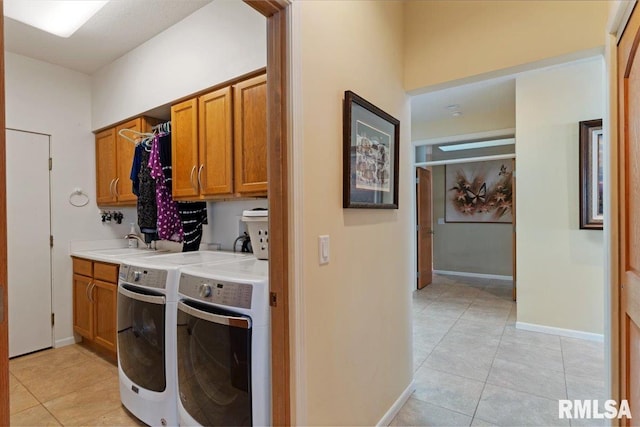 laundry room with washer and clothes dryer, cabinet space, light tile patterned floors, and baseboards
