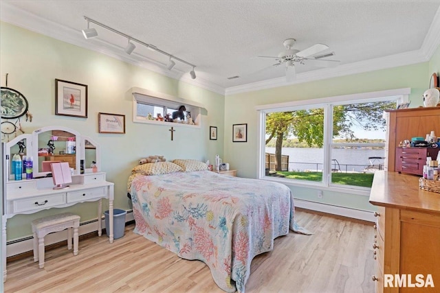 bedroom with a baseboard radiator, track lighting, light wood finished floors, a textured ceiling, and crown molding