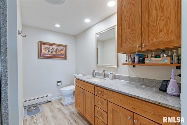 bathroom with baseboard heating, wood finished floors, vanity, toilet, and recessed lighting