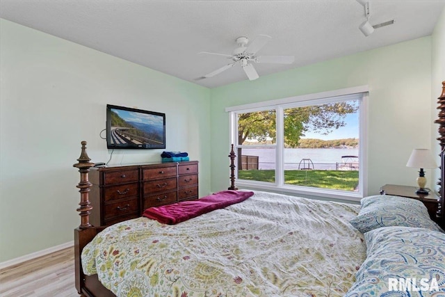 bedroom featuring wood finished floors, baseboards, and a ceiling fan