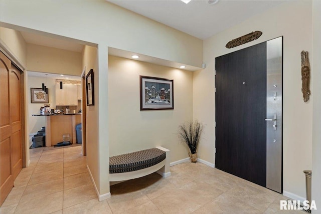 foyer entrance with light tile patterned flooring and baseboards
