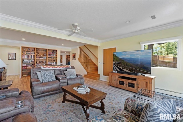 living area with stairway, crown molding, wood finished floors, ceiling fan, and baseboards