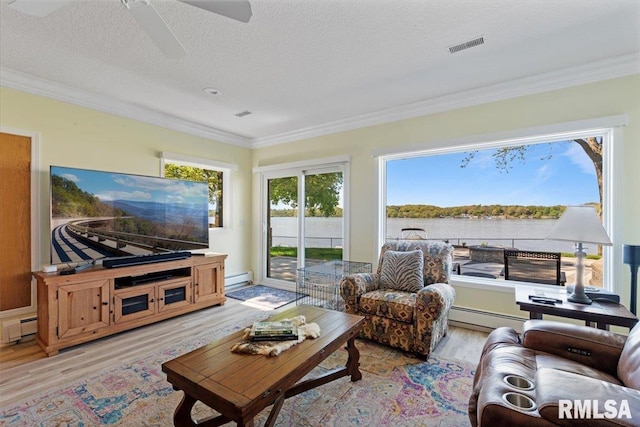 living area with light wood-style flooring, crown molding, a baseboard radiator, a baseboard heating unit, and a textured ceiling