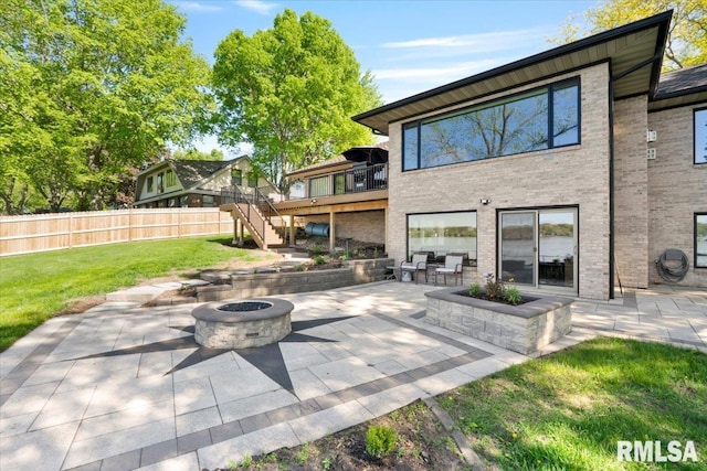 back of house featuring a fire pit, a patio, brick siding, and stairs