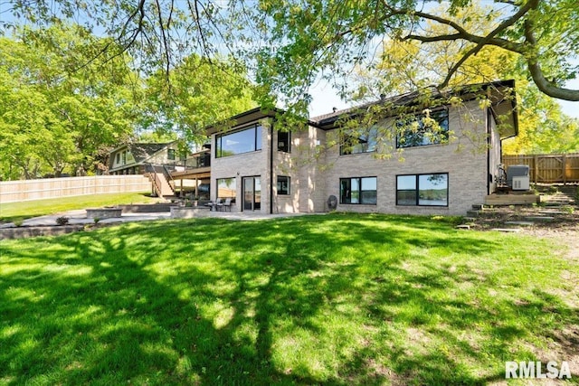 rear view of house with a wooden deck, stairs, and a patio area